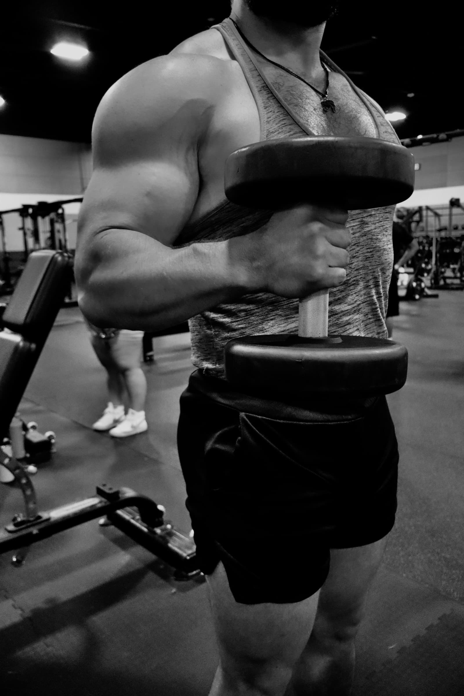 Close crop of a heavy dumbbell curl held at the top of the rep