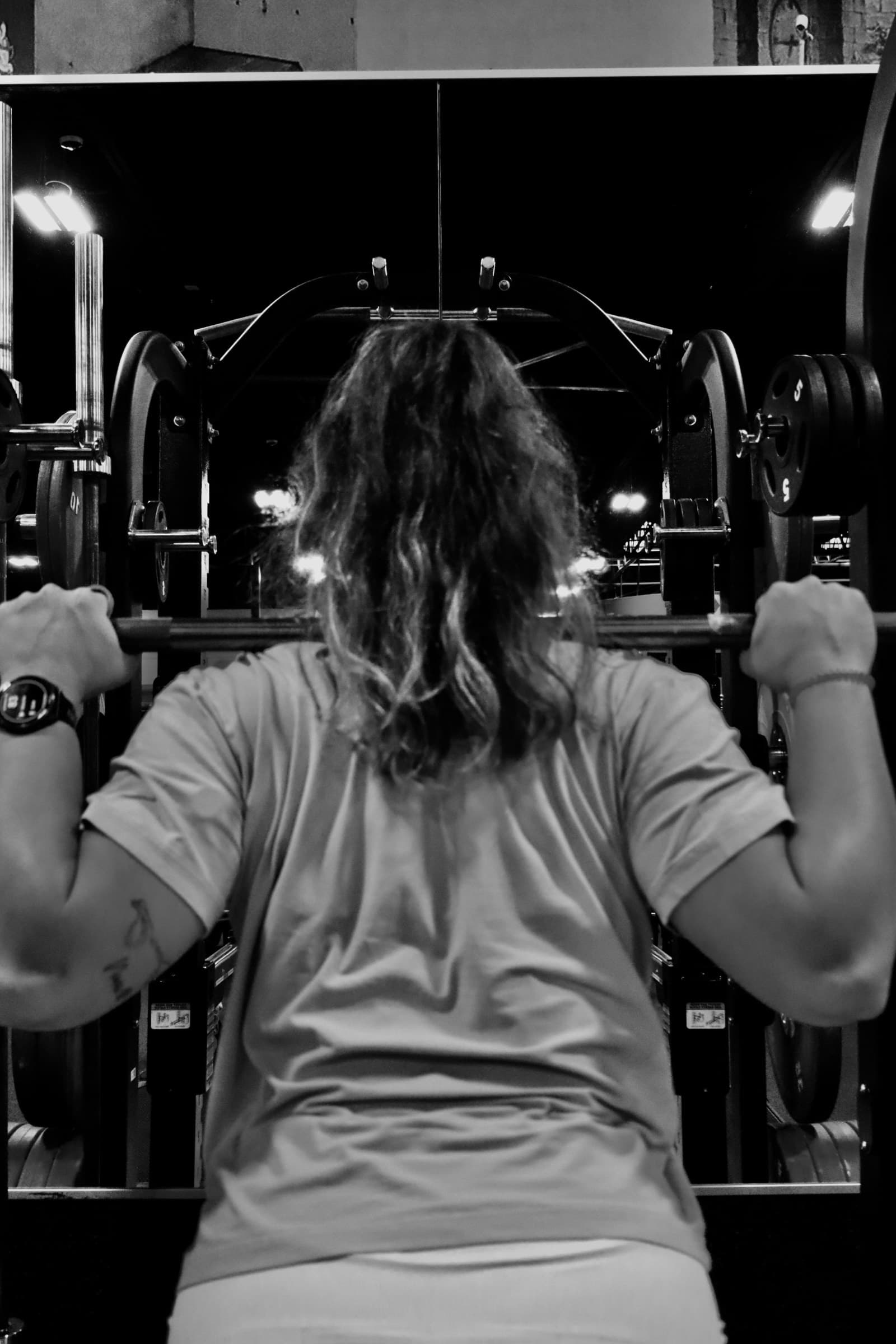 A lifter unracking a loaded barbell across their shoulders